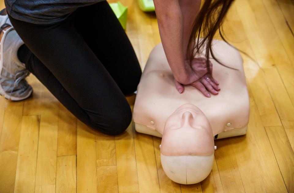 At the direction of Phillip Burton, a paramedic with Columbus Regional Health, students receive a lesson on using an automated external defibrillator, as well as CPR best practice, during a cardiac screening clinic at Columbus East High School in Columbus, Indiana. Feb. 24, 2023