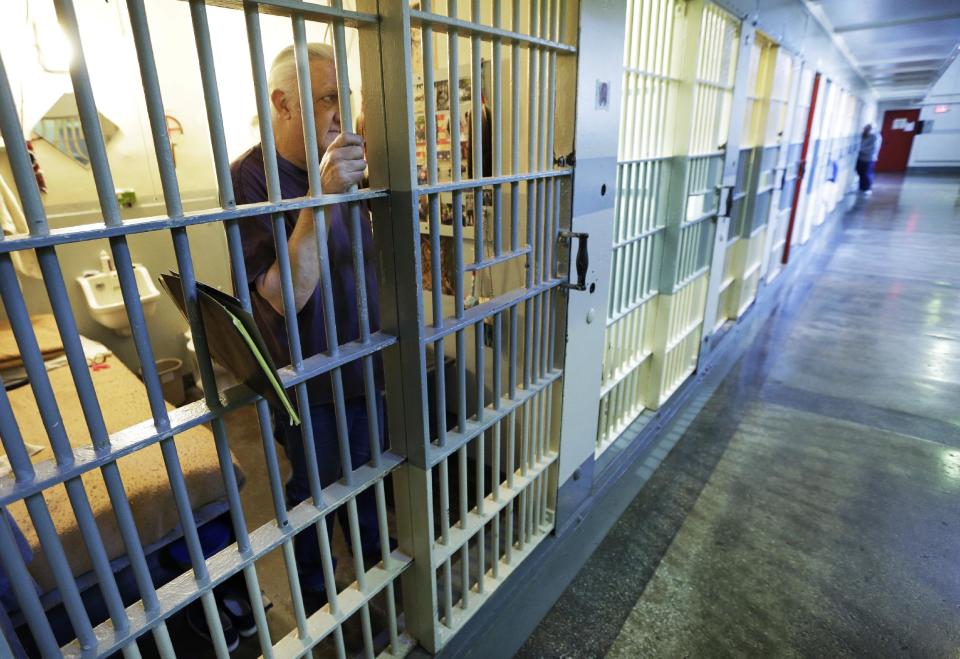 In this Nov. 18, 2013 photo, inmate Lloyd Bennett looks out his cell at the Iowa State Penitentiary in Fort Madison, Iowa. The penitentiary, the oldest in use west of the Mississippi River with a history dating back to 1839, is set to close when a $130 million replacement opens down the road next year. (AP Photo/Charlie Neibergall)