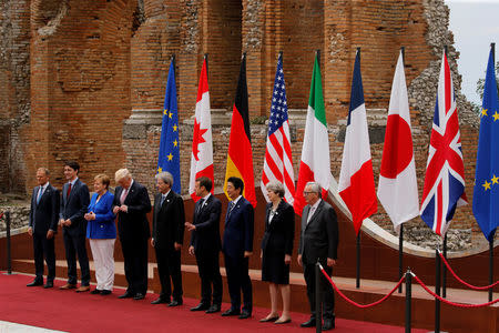 From L-R, European Council President Donald Tusk, Canadian Prime Minister Justin Trudeau, German Chancellor Angela Merkel, U.S. President Donald Trump, Italian Prime Minister Paolo Gentiloni, French President Emmanuel Macron, Japanese Prime Minister Shinzo Abe, Britain’s Prime Minister Theresa May and European Commission President Jean-Claude Juncker pose for a family photo at the Greek Theatre during the G7 Summit in Taormina, Sicily, Italy, May 26, 2017.. REUTERS/Jonathan Ernst