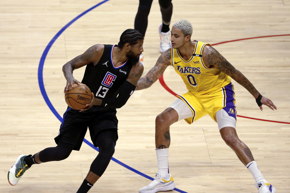 Los Angeles Clippers' Paul George (13) is defended by Los Angeles Lakers' Kyle Kuzma (0) during the second half of an NBA basketball game Thursday, May 6, 2021, in Los Angeles. (AP Photo/Ringo H.W. Chiu)