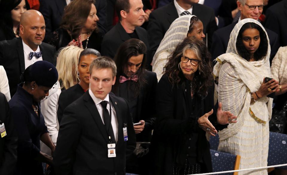 Singer Steven Tyler (2nd R) of Aerosmith and Dana Elaine Owens (2nd L), better known by her stage name Queen Latifah, attend the Nobel Peace Prize awards ceremony at the City Hall in Oslo December 10, 2014. Pakistani teenager Malala Yousafzai, shot by the Taliban for refusing to quit school, and Indian activist Kailash Satyarthi received their Nobel Peace Prizes on Wednesday after two days of celebration honouring their work for children's rights. REUTERS/Suzanne Plunkett (NORWAY - Tags: SOCIETY ENTERTAINMENT)