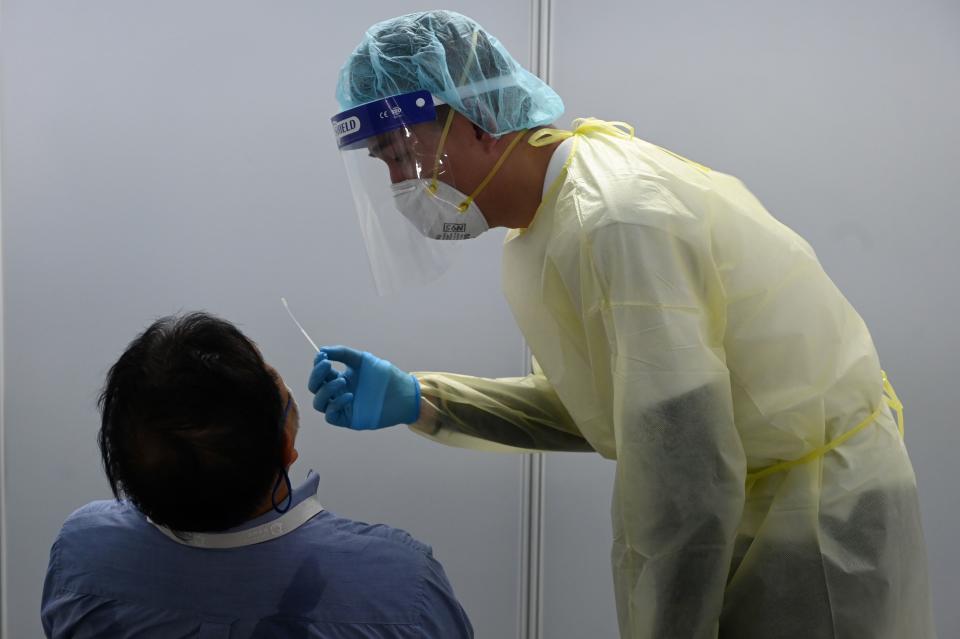 A health personnel conducts antigen rapid test for Covid-19 coronavirus to a passenger during embarkation procedures on World Dream cruise ship for "cruises to nowhere" at Marina Bay Cruise Centre in Singapore on November 6, 2020 in a bid to revive its pandemic-hit tourism industry. (Photo by Roslan Rahman / AFP) (Photo by ROSLAN RAHMAN/AFP via Getty Images)