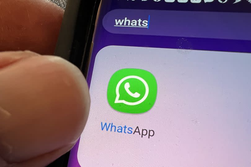 Close-up of icon for Whatsapp messaging app on cellphone, Lafayette, California, with person's hand visible