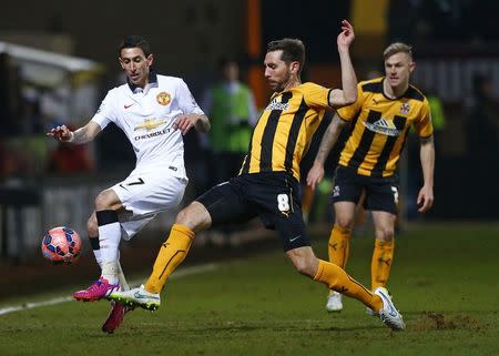 Manchester United's Angel Di Maria (L) is challenged by Cambridge United's Tom Champion during their English FA Cup 4th round soccer match at The Abbey Stadium in Cambridge, eastern England January 23, 2015. REUTERS/Andrew Winning