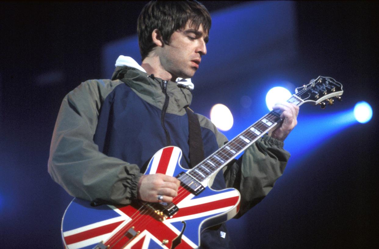 UNITED KINGDOM - APRIL 01:  Photo of Noel GALLAGHER and BRITPOP and OASIS; Noel Gallagher performing live onstage, playing Epiphone Sheraton Union Jack guitar at Maine Road, Britpop  (Photo by Patrick Ford/Redferns)