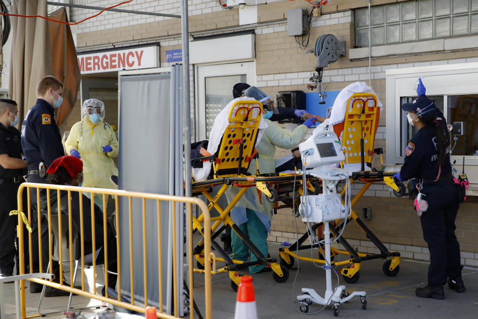 ARCHIVO - La paramédica de Nueva York Elizabeth Bonilla, a la derecha, lleva a un paciente a la zona de ingresos de urgencias en el Hospital Montefiore, el 15 de abril de 2020, en el barrio de Nueva York. La amenaza de huelga crecía en medio de las negociaciones entre tres hospitales neoyorquinos y el sindicato que representaba a casi 9.000 enfermeras. (AP Foto/John Minchillo, Archivo)