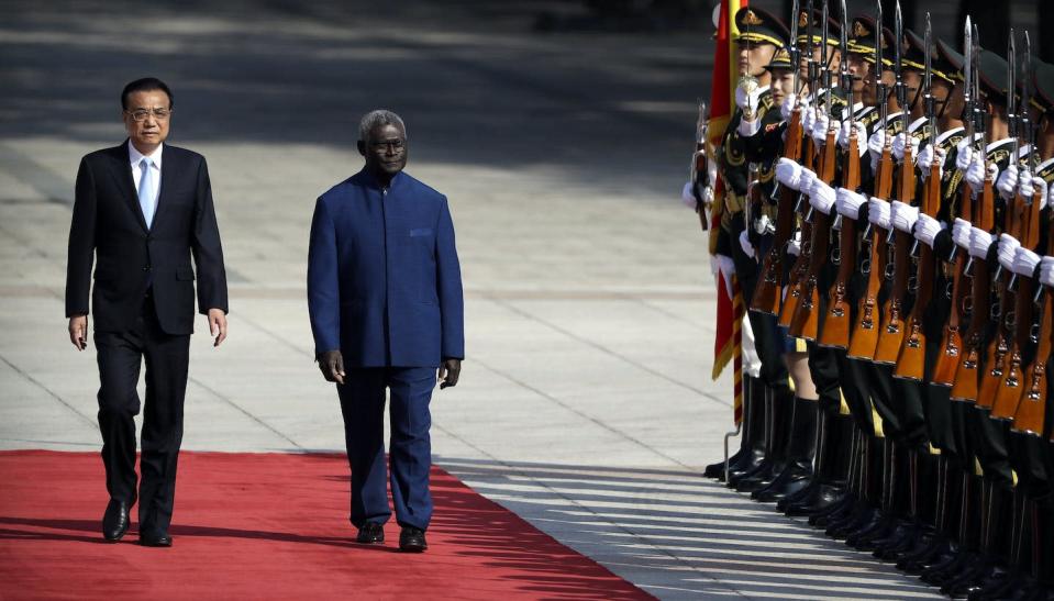 Chinese Premier Li Keqiang, left, and Solomon Islands Prime Minister Manasseh Sogavare review an honor guard in Beijing AP