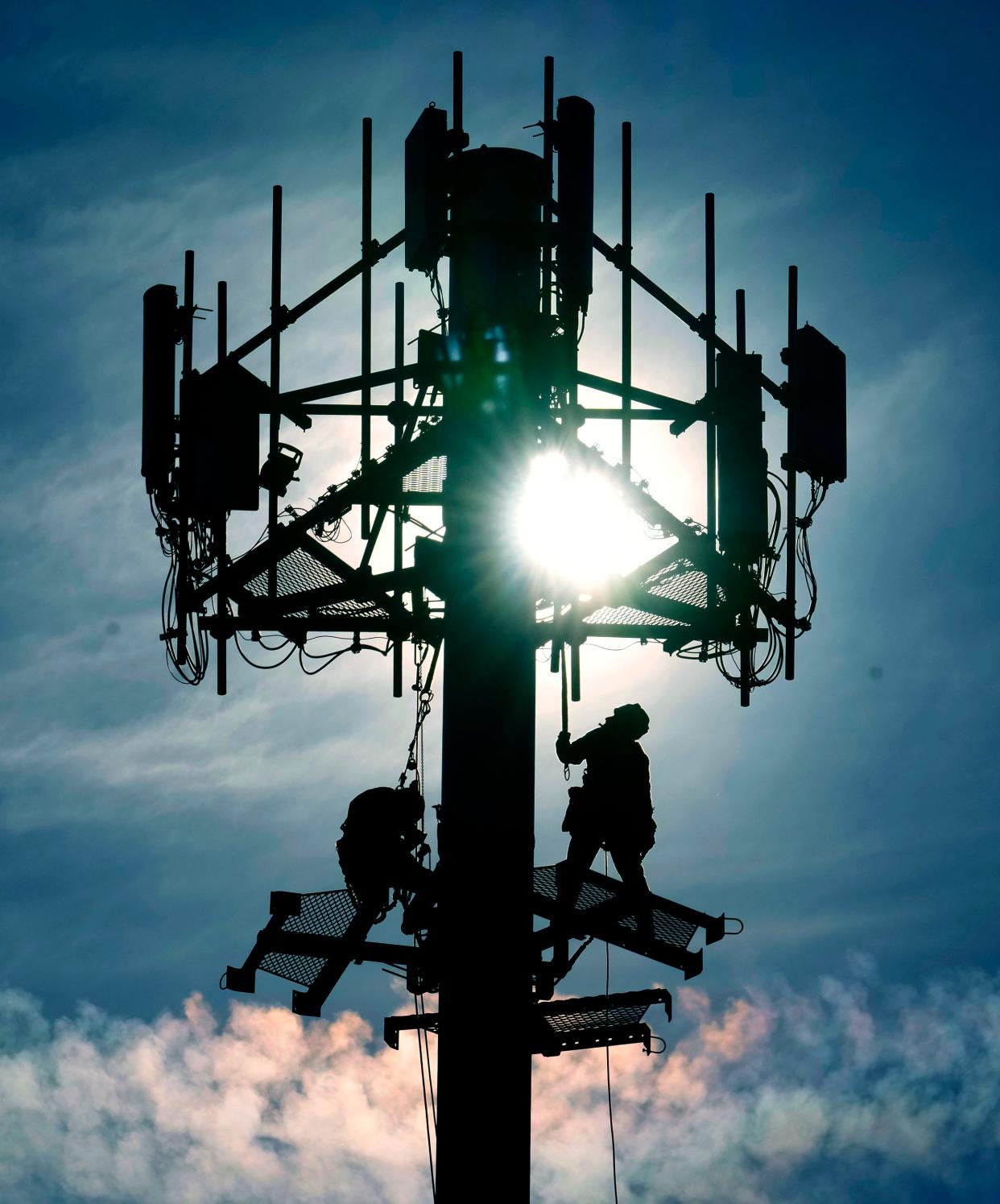 Crews work on installing cellular equipment on a communications tower in the Fox Point shopping plaza on West Brown Deer Road on Tuesday, March 21, 2023.