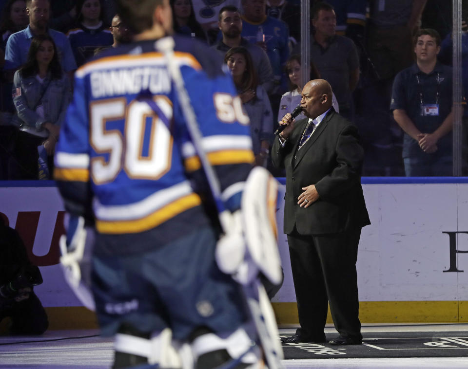 Charles Glenn sings the national anthem as St. Louis Blues goaltender Jordan Binnington (50) listens before the start of Game 6 of the NHL hockey Stanley Cup Final between the Blues and the Boston Bruins Sunday, June 9, 2019, in St. Louis. (AP Photo/Jeff Roberson)