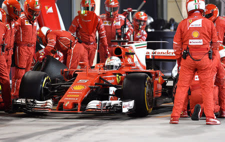 Formula One - F1 - Bahrain Grand Prix - Sakhir, Bahrain - 16/04/17 - Pit crew and mechanics surround Ferrari's German driver Sebastian Vettel in the pit lane. REUTERS/Andrej Isakovic/Pool