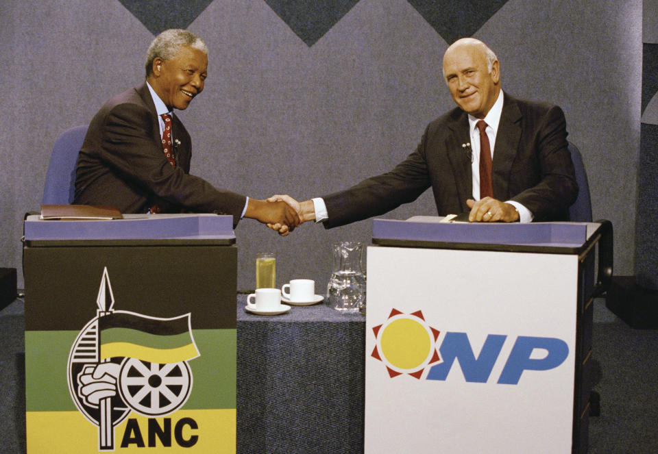 FILE — In this April 14, 1994, file photo taken by South African Photographer John Parker African National Congress President Nelson Mandela, left, and South African President F.W. de Klerk, shake hands prior to a television debate in Johannesburg. Parkin, who covered the country's anti-apartheid struggle, its first democratic elections, and the presidency of Nelson Mandela, has died Monday Aug. 23, 2021, at the age of 63 according to his daughter. (AP Photo/John Parkin/Pool)