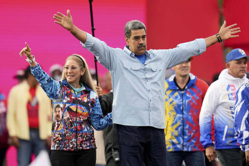 El presidente venezolano Nicolás Maduro abre sus brazos durante el recorrido por el cierre de campaña junto a la Primera Dama, Cilia Flores, en Caracas, Venezuela, el jueves 25 de julio de 2024. Maduro busca la reelección para un tercer período en las elecciones del 28 de julio. (AP Foto/Fernando Vergara)