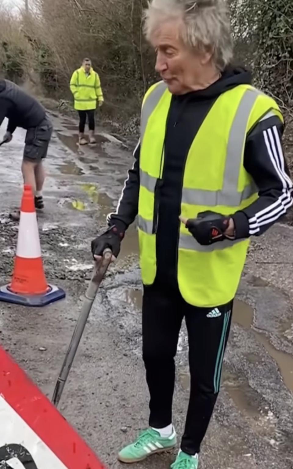 Rod Stewart in hi-vis filling in potholes