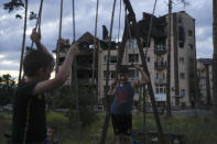 Children play near a building destroyed during Russian attacks in Irpin, on the outskirts of Kyiv, Ukraine, Sunday, June 12, 2022. (AP Photo/Natacha Pisarenko)