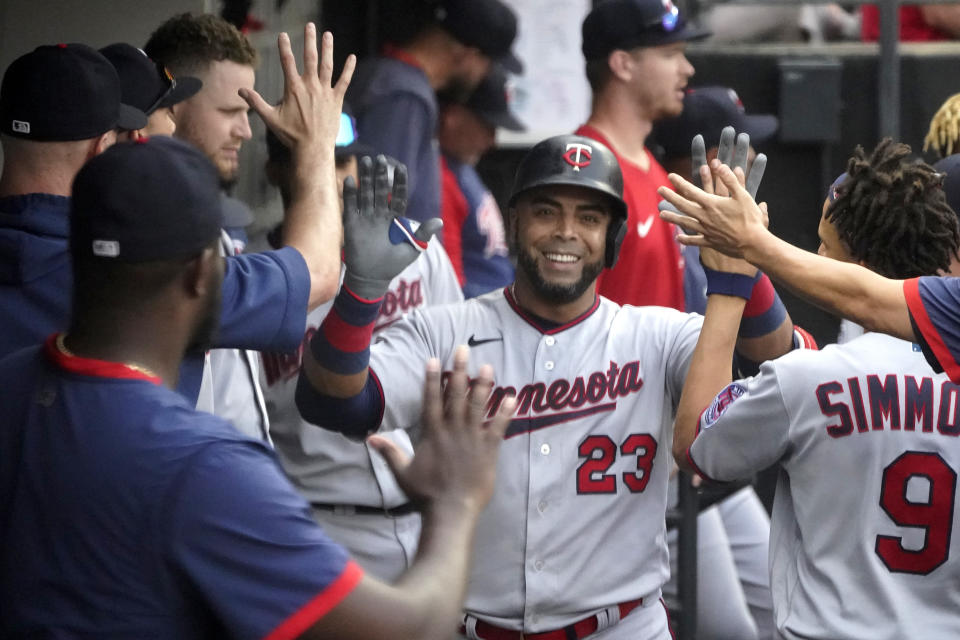 Minnesota Twins' Nelson Cruz celebrates in the dugout his home run off Chicago White Sox's Lance Lynn during the sixth inning of a baseball game Monday, July 19, 2021, in Chicago. (AP Photo/Charles Rex Arbogast)