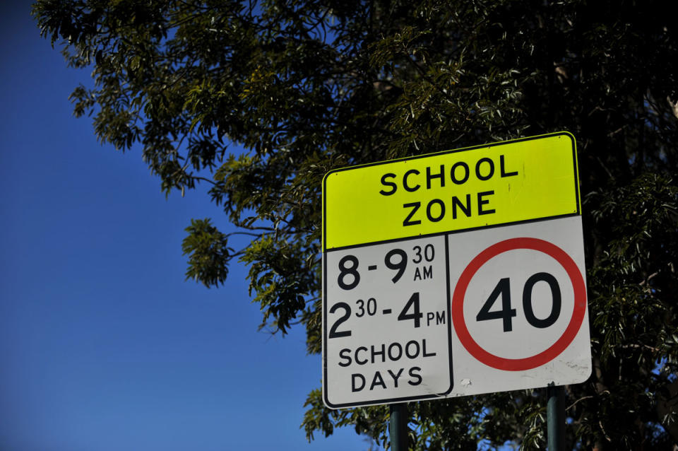 A sign warning of a school zone ahead stands on the side of the road in Sydney