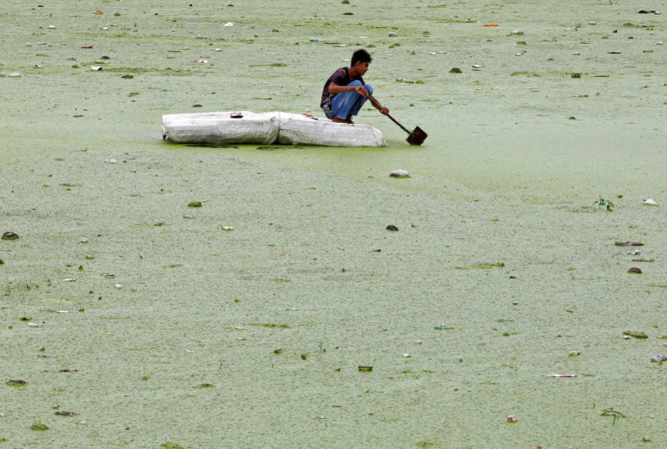 <p>A boy rows his makeshift raft in the weed covered Sabarmati river in Ahmedabad, India July 27, 2016. (Photo: Amit Dave/Reuters)</p>