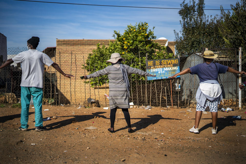 People practice safe distancing as they line up to receive food handouts in the Olievenhoutbos township of Midrand, South Africa, Saturday May 2, 2020. though South Africa begun a phased easing of its strict lockdown measures on May 1, its confirmed cases of coronavirus continue to increase. (AP Photo/Jerome Delay)