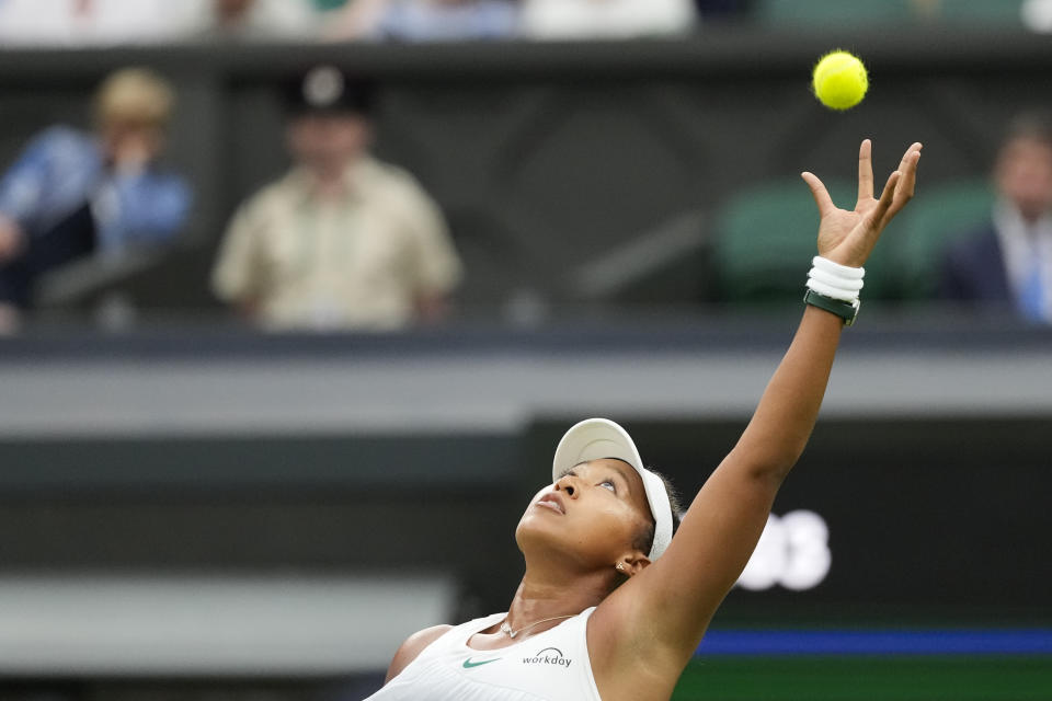 Naomi Osaka of Japan reaches up to catch the ball during her second round match against Emma Navarro of the United States at the Wimbledon tennis championships in London, Wednesday, July 3, 2024. (AP Photo/Alberto Pezzali)
