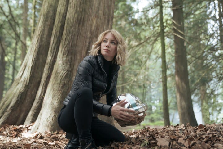 Jennifer Holland holds one of Peacemaker's helmets in a scene from the series.