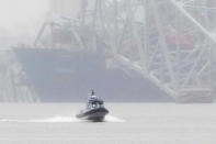 A container ship rests against the wreckage of the Francis Scott Key Bridge during a rainstorm on Wednesday, March 27, 2024, in Baltimore, Md. The ship rammed into the major bridge in Baltimore early Tuesday, causing it to collapse in a matter of seconds and creating a terrifying scene as several vehicles plunged into the chilly river below. (AP Photo/Matt Rourke)