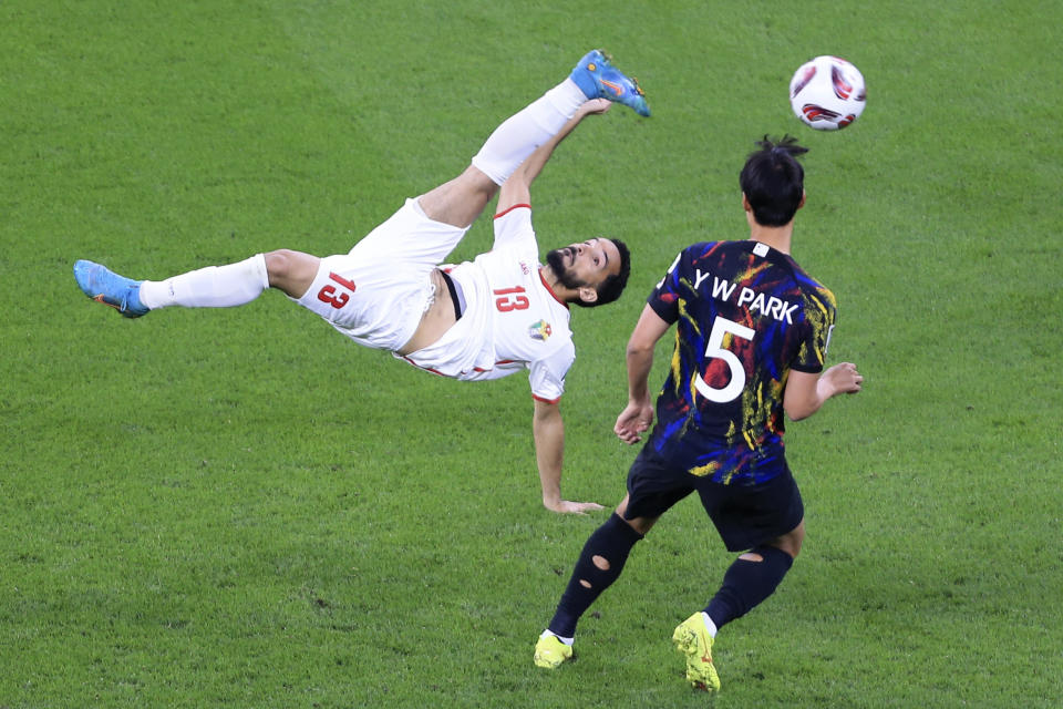 Jordan's Mahmoud Almardi, left, does a bicycle kick as South Korea's Park Yong-woo watches during the Asian Cup semifinal soccer match between South Korea and Jordan at Ahmad Bin Ali Stadium in Al Rayyan, Qatar, Tuesday, Feb. 6, 2024. (AP Photo/Hussein Sayed)