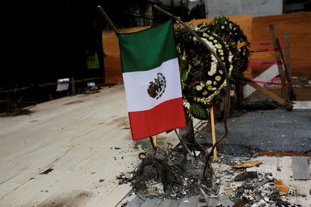 The Mexican flag and flowers are seen in tribute to the victims where a building collapsed in an earthquake in Mexico City, Mexico September 27, 2017. REUTERS/Nacho Doce