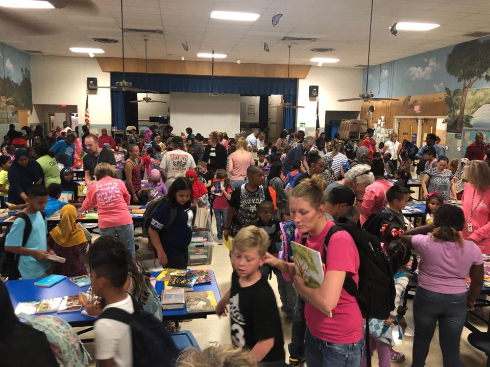 Elementary school students choosing their books from the Storybridge book fair to take home and keep.