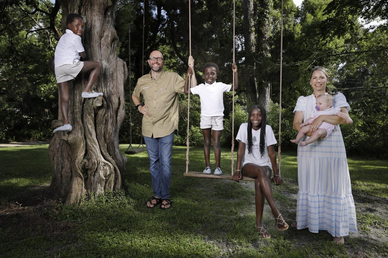 The West family gathers around a double seat swing made by the family business, Southern Pine Swing Co., which Zac West began during the pandemic. From left: Josiah, 6; his father Zac; Josiah's twin brother, Joshua; Zara, 13; and their mother Hannah, who's holding the newest member of the family, Gwen, 6 months.