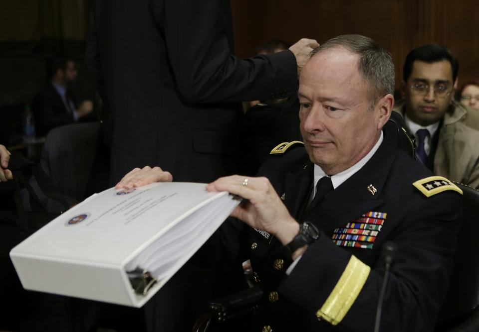 U.S. NSA Director General Alexander pulls out a binder before testifying at the Senate Judiciary Committee in Washington