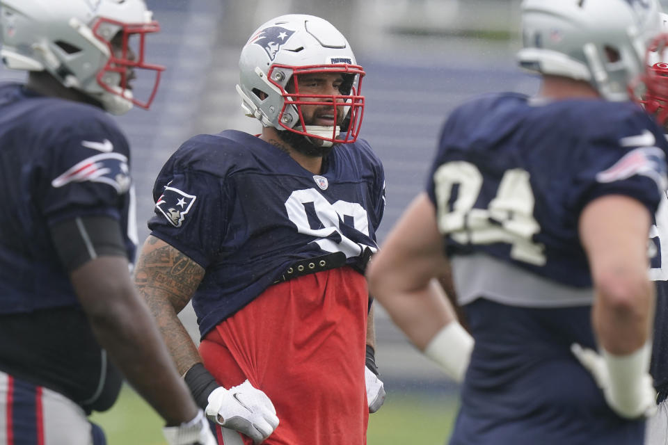 New England Patriots defensive tackle Lawrence Guy, center, warms up during an NFL football practice, Wednesday, Sept. 22, 2021, in Foxborough, Mass. (AP Photo/Steven Senne)