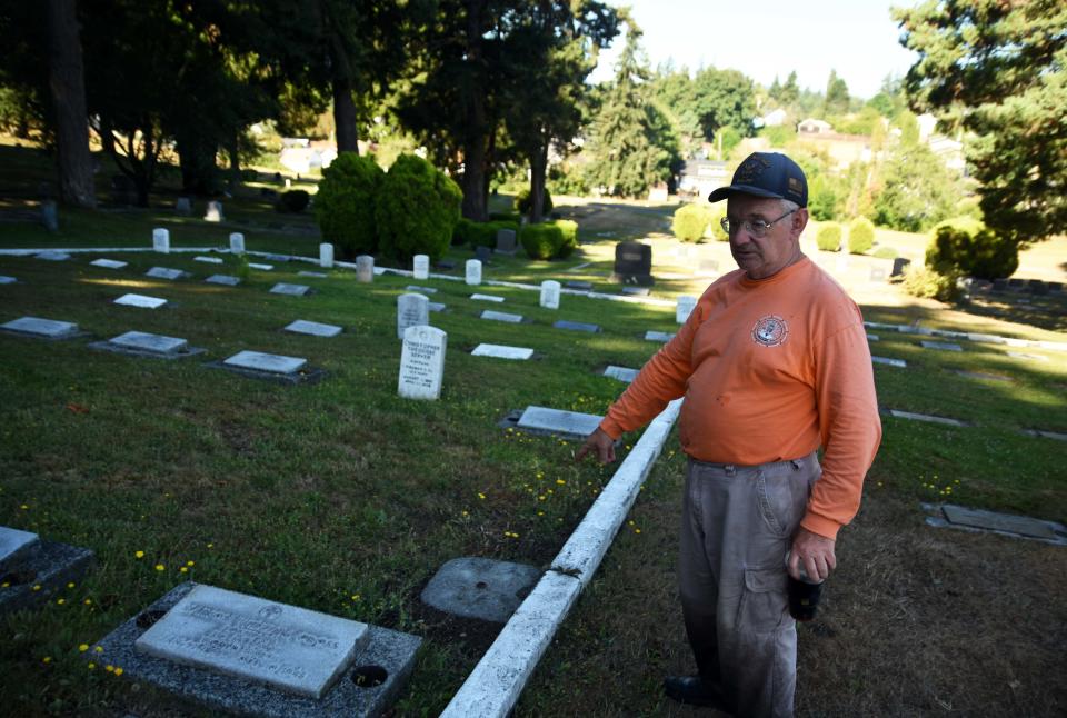 Mick Hersey points to the area where he's planning to build a flower box using yellow bricks from the old Harrison Hospital in Bremerton.