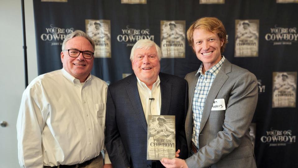 Jerry Hodge, center, takes a photo Wednesday with both of his autobiography ghostwriters, Les Simpson, left, and Ben Masters at Hodgetown during his book launch party.