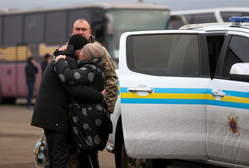 A Ukrainian citizen embraces a relative after the exchange of prisoners of war between Ukraine and the separatist republics near the Mayorsk crossing point in Donetsk region