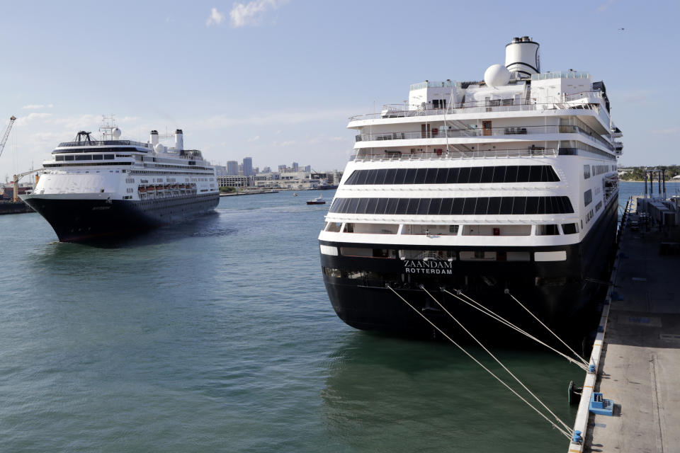 Carnival's Holland America cruise ship Rotterdam, left, arrives at Port Everglades as the Zaandam, right, is docked during the new coronavirus pandemic, Thursday, April 2, 2020, in Fort Lauderdale, Fla. Those passengers that are fit for travel in accordance with guidelines from the U.S. Centers for Disease Control will be permitted to disembark. (AP Photo/Lynne Sladky)