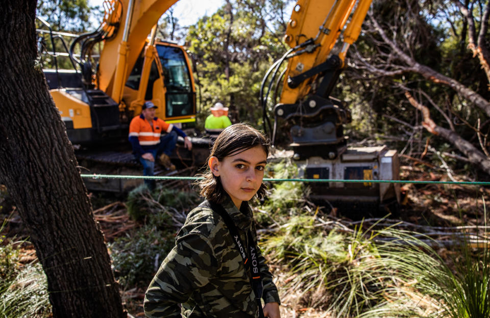 Spencer Hitchen in front of a bulldozer at the development site.