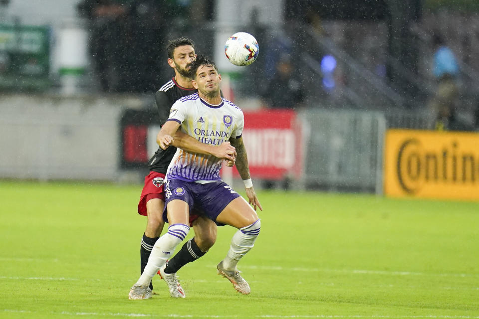 D.C. United defender Steve Birnbaum, back, and Orlando City forward Alexandre Pato compete for the ball during the second half of an MLS soccer match, Sunday, July 31, 2022, in Washington. D.C. United won 2-1. (AP Photo/Julio Cortez)