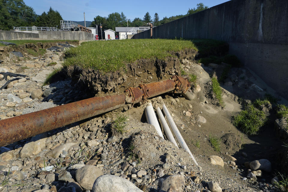 A sewer pipe is exposed due to eroded land at the wastewater treatment plant following July flooding, Wednesday, Aug. 2, 2023, in Ludlow, Vt. Across the U.S., municipal water systems and sewage treatment plants are at increasing risk of damage from floods and sea-level rise brought on in part or even wholly by climate change. The storm that walloped Ludlow especially hard, damaging the picturesque ski town’s system for cleaning up sewage before it’s discharged into the Williams River. (AP Photo/Charles Krupa)