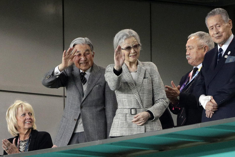 Japan's former emperor Akihito and Empress Michiko waves during the Rugby World Cup bronze final game at Tokyo Stadium between New Zealand and Wales in Tokyo, Japan, Friday, Nov. 1, 2019. (AP Photo/Aaron Favila )
