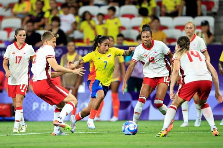 La delantera colombiana Manuela Paví (centro) enfrenta a cuatro jugadoras canadienses durante el partido entre Colombia y Canadá, por el cierre del Grupo A del torneo femenino de fútbol de los Juegos Olímpicos de París, disputado en el estadio de Niza el 31 de julio de 2024. (Valery HACHE)