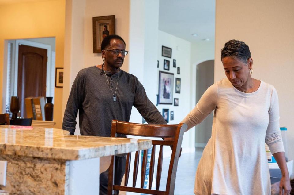 Carla Preyer leads her husband, Patrick Preyer, who has Lewy body dementia, to a seat at the counter to eat a meal at home in Rancho Cordova on Wednesday, Feb. 24, 2021.