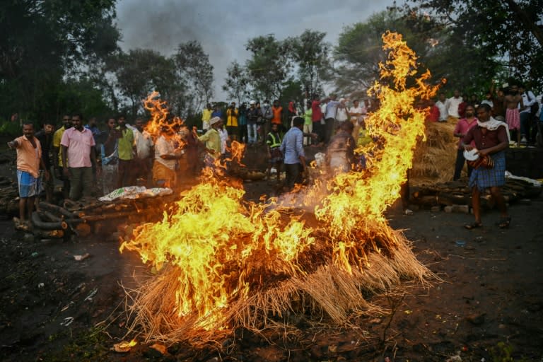 Family members perform last rites during the funeral of victims who died after consuming toxic alcohol (R.Satish BABU)