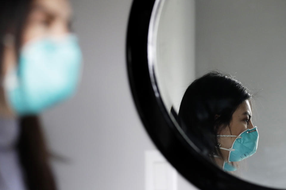 Francy Sandoval poses for a portrait at her home in Melrose Park, Ill., Thursday, April 23, 2020. She works as a receptionist at a community health clinic which treats multiple COVID-19 cases. She has to isolate herself in the attic as soon as she comes home from work each day and is terrified of infecting her family. (AP Photo/Nam Y. Huh)