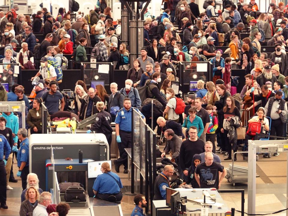 Travelers navigate a security checkpoint at Denver International Airport.