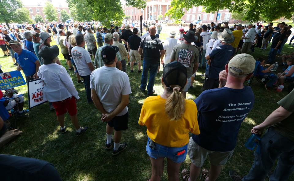 People seek shade as they attend a pro-gun rights rally on the Legislative Mall in Dover, Saturday, June 25, 2022.