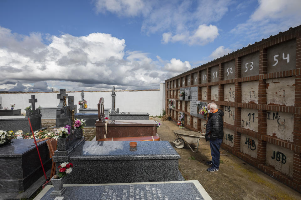 CORRECTS NAME OF MAN - Julian Fernandez Mascaraque, 59, attends the burial of her mother Rosalia Mascaraque, 86, during the coronavirus outbreak in Zarza de Tajo, central Spain, Wednesday, April 1, 2020. The new coronavirus causes mild or moderate symptoms for most people, but for some, especially older adults and people with existing health problems, it can cause more severe illness or death. (AP Photo/Bernat Armangue)