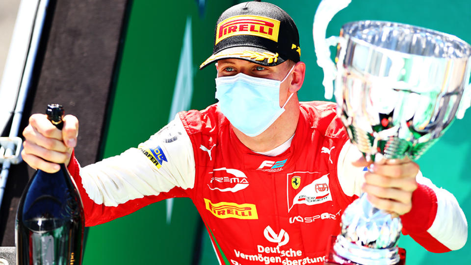 Mick Schumacher is pictured holding the trophy and champagne after winning the F2 feature race at Monza.