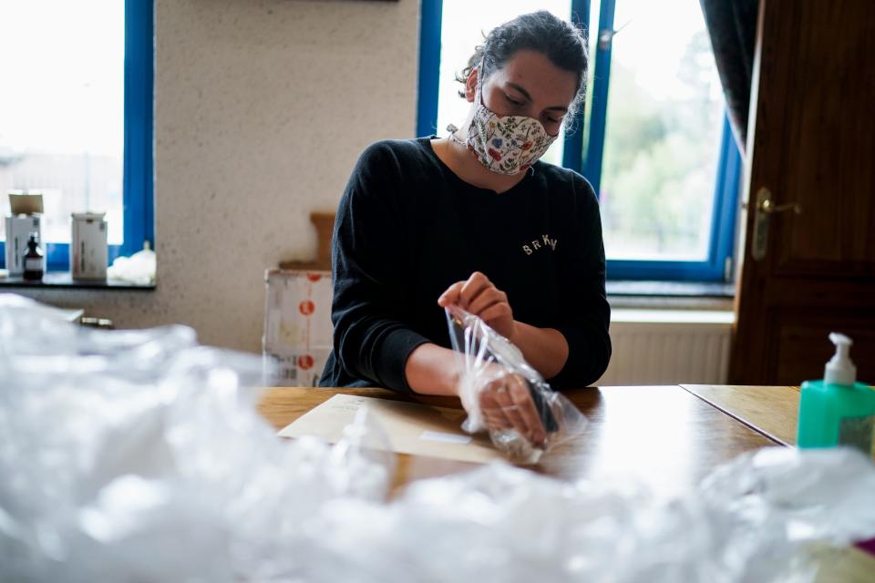 Municipal employees put masks in envelopes to send the town's residents in Lincent on April 28, 2020, during a lockdown in the country aimed at curbing the spread of the COVID-19 pandemic, caused by the novel coronavirus. - Belgian municipalities are starting to provide their residents with washable masks, as the country prepares to ease coronavirus lockdown measures. (Photo by Kenzo TRIBOUILLARD / AFP) (Photo by KENZO TRIBOUILLARD/AFP via Getty Images)