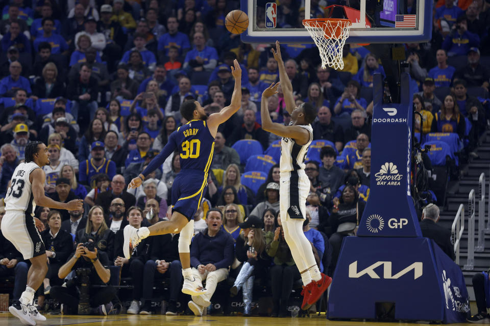 Golden State Warriors guard Stephen Curry (30) shoots against San Antonio Spurs guard Malaki Branham, right, during the first half of an NBA basketball game in San Francisco, Friday, March 31, 2023. (AP Photo/Jed Jacobsohn)