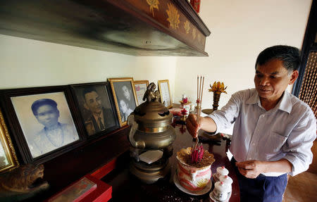 Colonel Vo Cao Tri places incenses in front of his mother's portrait, who was killed by US soldiers during the My Lai massacre on March 16, 1968, at his house in Danang, Vietnam March 14, 2016. Picture taken on March 14, 2018. REUTERS/Kham